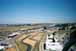 An overhead view of the main grandstand area and the main paddock building with paddock hospitality and pit garages. 